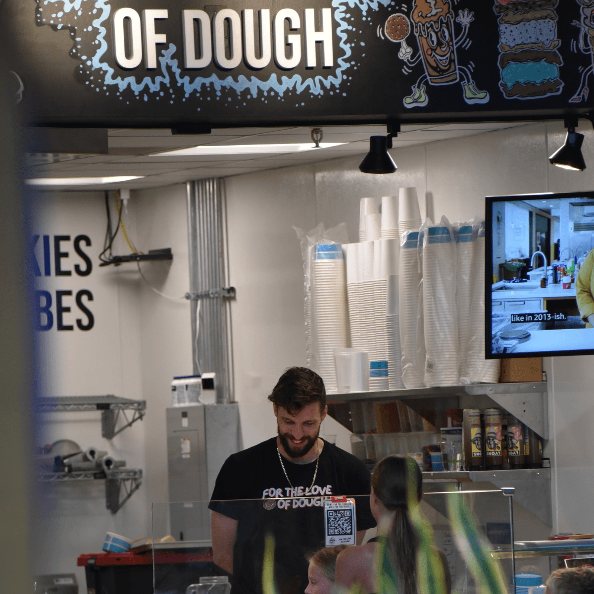 co-owner of for the love of dough helping a customer