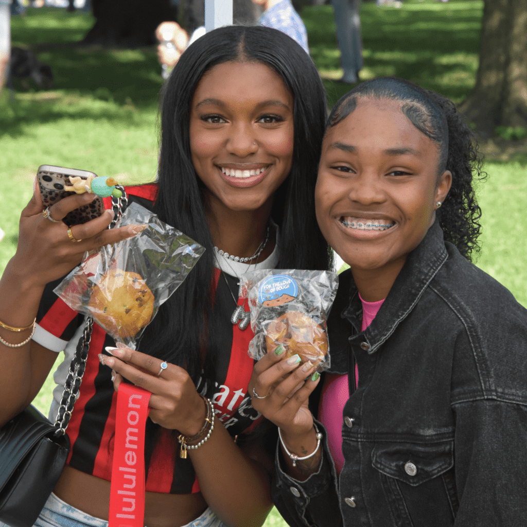 Two women smiling with For the Love of Dough cookies in hand